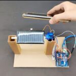 A working model of a solar tracking system, showing a solar panel connected to an Arduino, servo motor, and sensors, with a hand testing light direction.